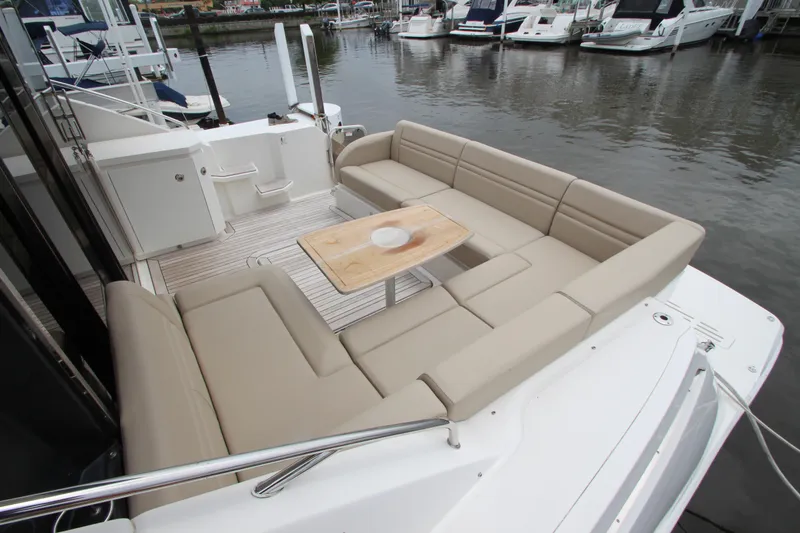 Slide: The Image of 2016 Sea Ray 510 Sundancer yacht with spacious outdoor seating area and table. - 15