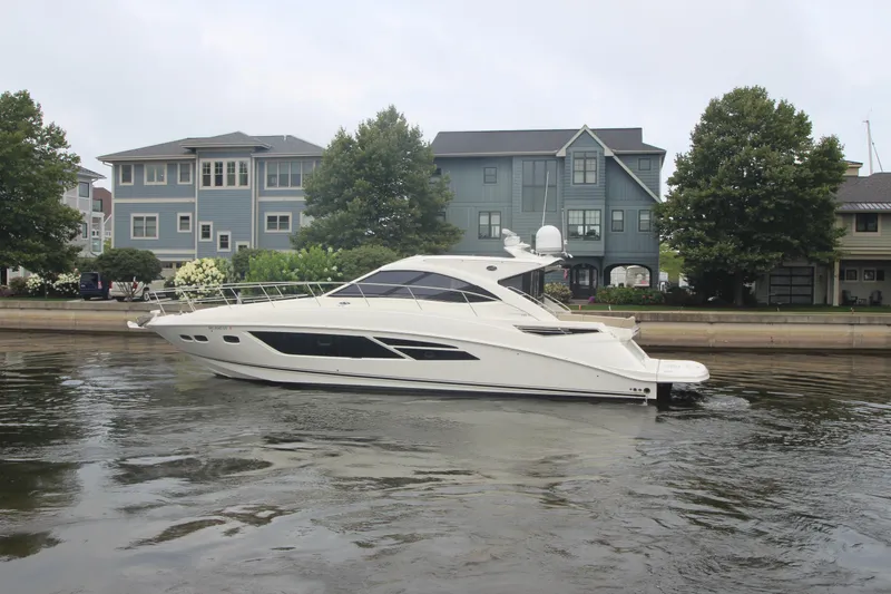 Slide: The Image of 2016 Sea Ray 510 Sundancer yacht cruising near waterfront homes. - 2