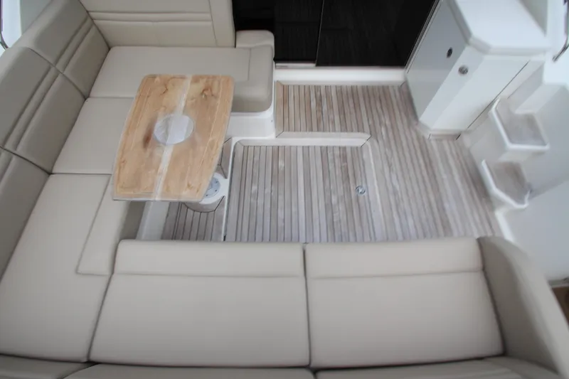 Slide: The Image of 2016 Sea Ray 510 Sundancer interior with beige seating and wooden table. - 20