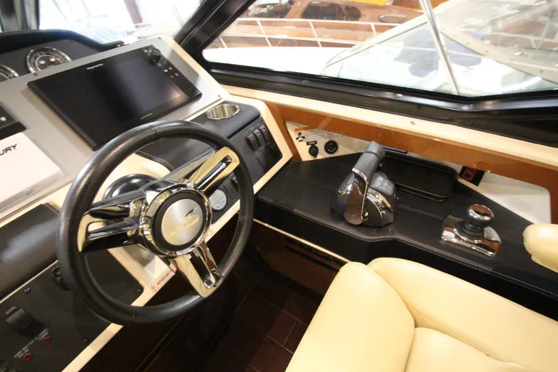 Slide: The Image of 2016 Sea Ray 510 Sundancer helm with steering wheel, controls, and navigation display. - 42