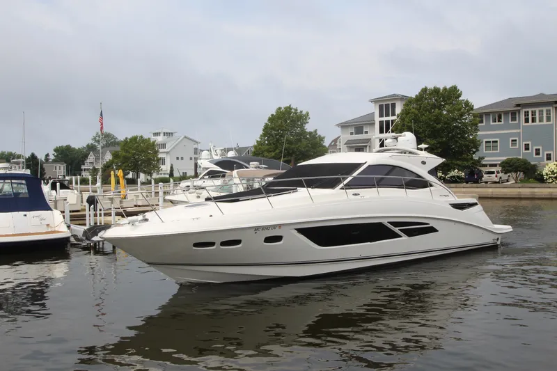 Slide: The Image of 2016 Sea Ray 510 Sundancer yacht docked in a marina, surrounded by waterfront homes. - 7