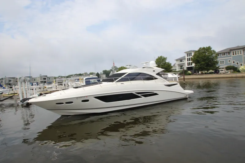 Slide: The Image of 2016 Sea Ray 510 Sundancer yacht docked in a marina with waterfront homes. - 9