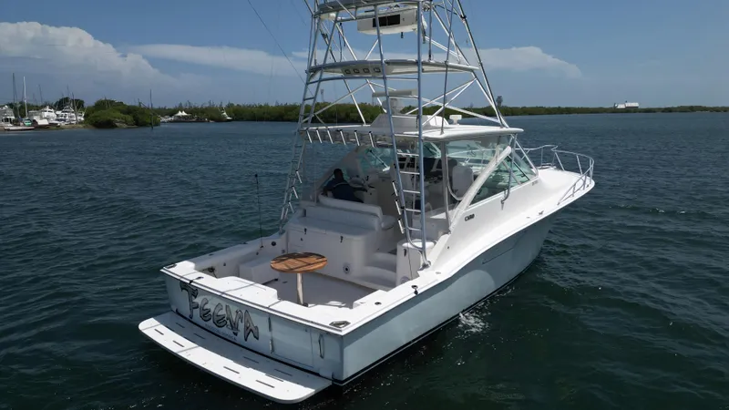 Slide: The Image of 2007 Cabo 40 Hardtop Express boat on calm water, featuring a spacious deck and tower. - 12