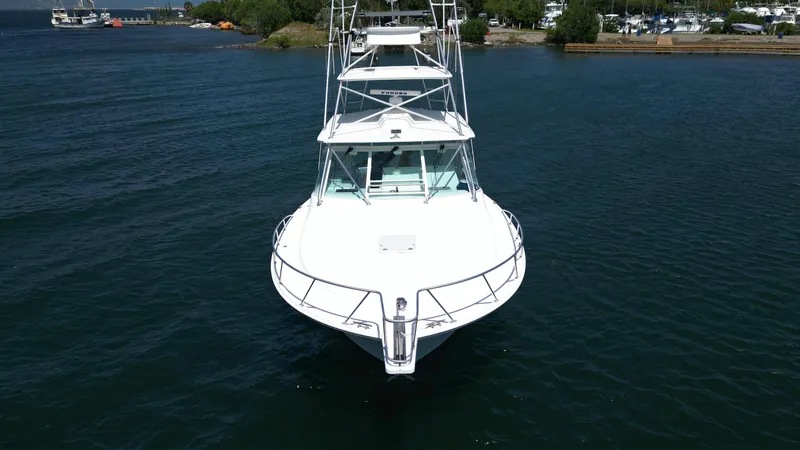 Slide: The Image of 2007 Cabo 40 Hardtop Express boat on calm water, front view. - 13