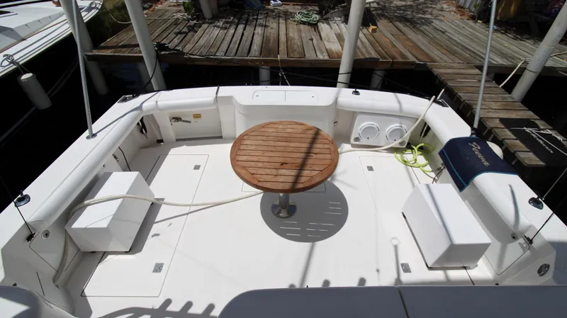Slide: The Image of 2007 Cabo 40 Hardtop Express boat deck with round wooden table and seating. - 17