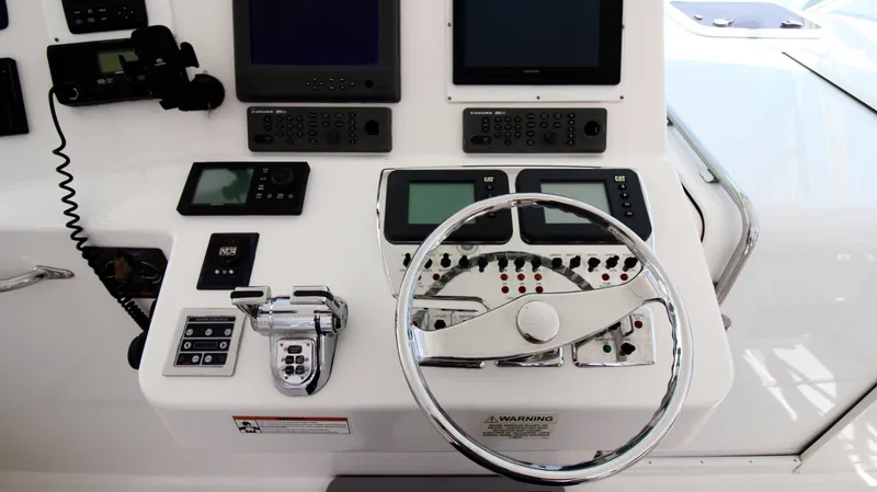 Slide: The Image of Control panel of a 2007 Cabo 40 Hardtop Express boat with steering wheel and navigation instruments. - 18