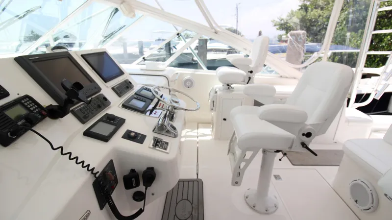 Slide: The Image of 2007 Cabo 40 Hardtop Express helm with advanced navigation equipment and white captain's chairs. - 20