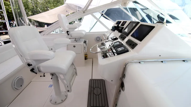 Slide: The Image of 2007 Cabo 40 Hardtop Express helm with white seating and advanced navigation controls. - 22