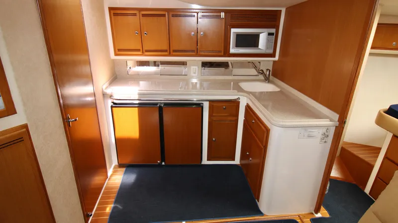 Slide: The Image of 2007 Cabo 40 Hardtop Express yacht kitchen with wood cabinets and modern appliances. - 24