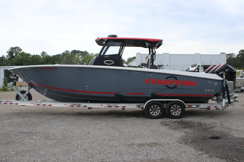 Slide: The Image of 2024 Fountain 32 NX boat on trailer, gray with red accents, parked outdoors. - 1