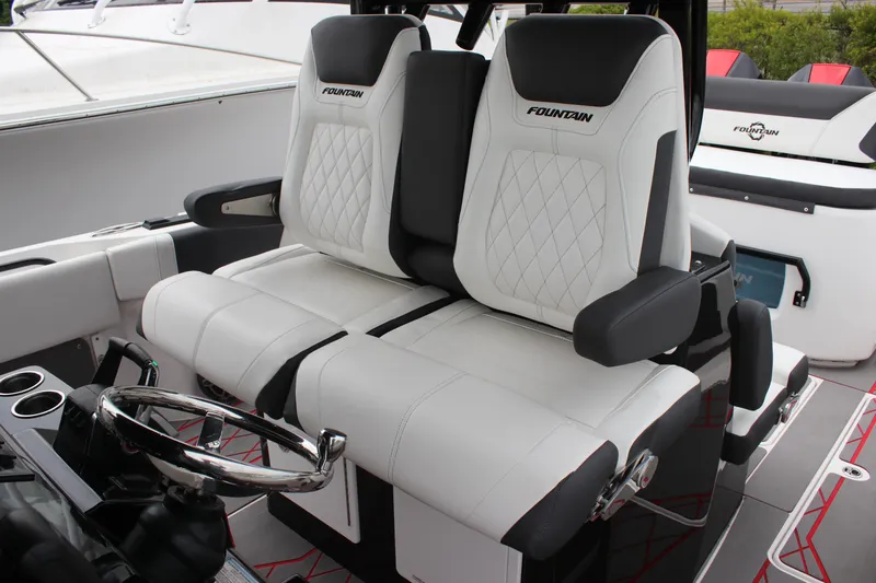 Slide: The Image of 2024 Fountain 32 NX boat interior with luxurious white seating and steering wheel. - 12