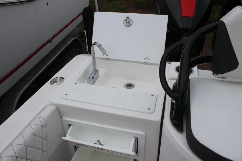Slide: The Image of 2024 Fountain 32 NX boat sink and storage area with modern design. - 13