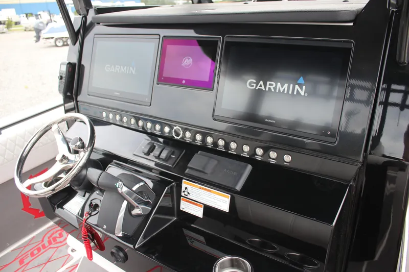 Slide: The Image of 2024 Fountain 32 NX boat dashboard with Garmin displays and steering wheel. - 9