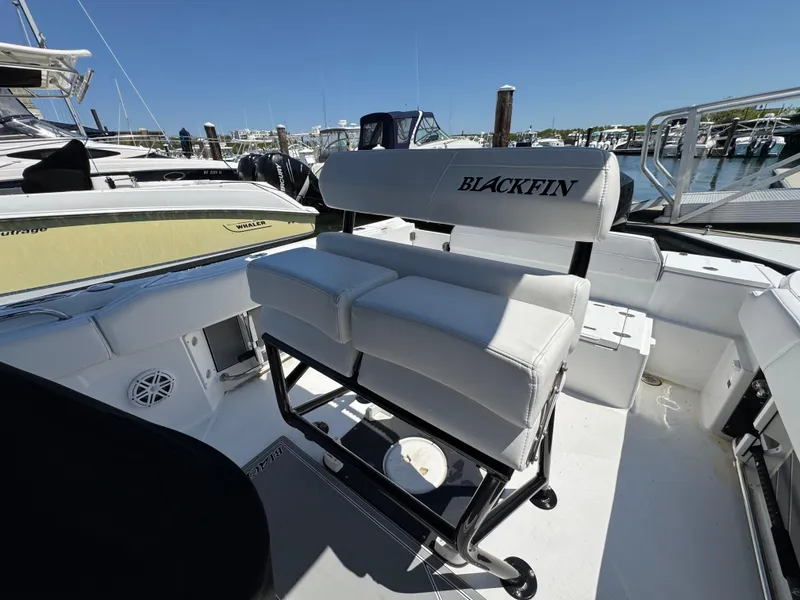 Slide: The Image of 2020 Blackfin 212 CC boat interior with white seating at a marina. - 14