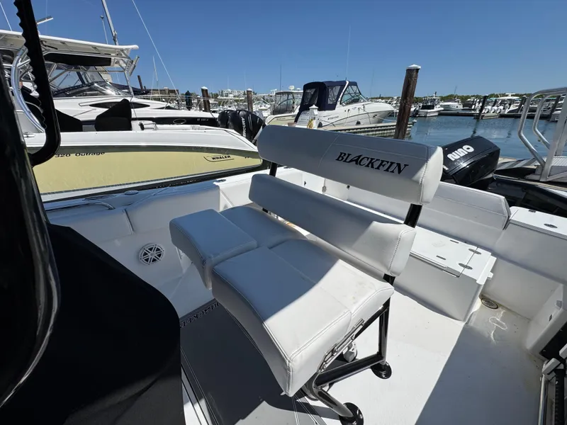 Slide: The Image of 2020 Blackfin 212 CC boat interior with white seating at a marina. - 15
