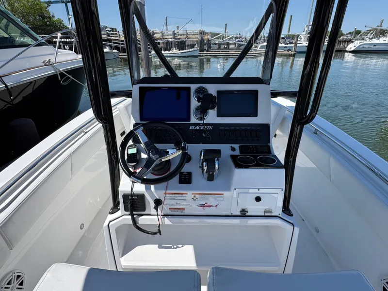 Slide: The Image of 2020 Blackfin 212 CC boat console with steering wheel and navigation screens at marina. - 16