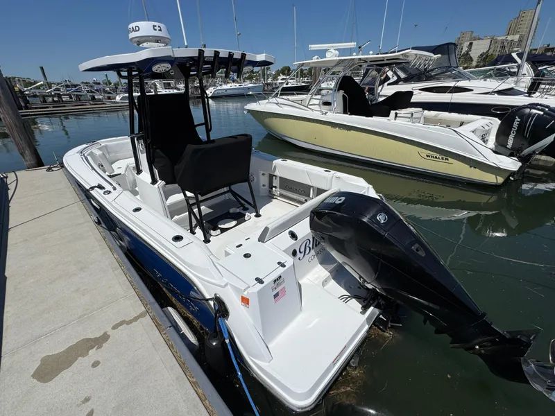 Slide: The Image of 2020 Blackfin 212 CC boat docked at marina, featuring sleek design and powerful outboard motor. - 2