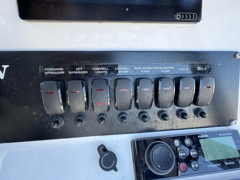 Slide: The Image of Control panel of a 2020 Blackfin 212 CC boat with labeled switches and a Fusion stereo. - 20