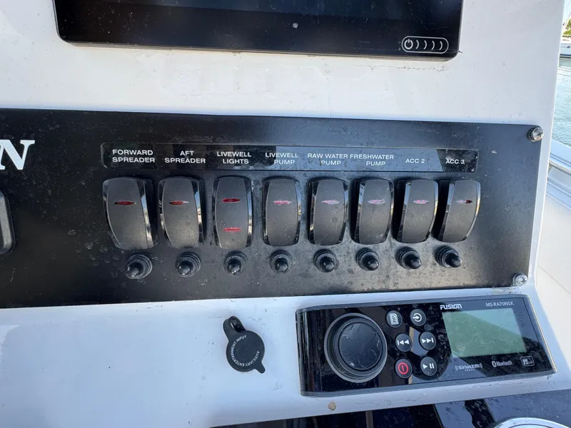 Slide: The Image of Control panel of a 2020 Blackfin 212 CC boat with switches and a Fusion stereo system. - 21