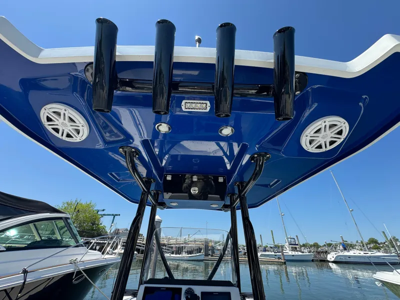 Slide: The Image of 2020 Blackfin 212 CC boat with blue T-top and rod holders at marina. - 26