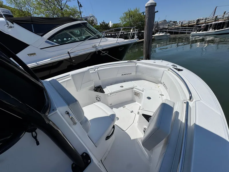 Slide: The Image of 2020 Blackfin 212 CC boat interior at marina, featuring sleek seating and modern design. - 28