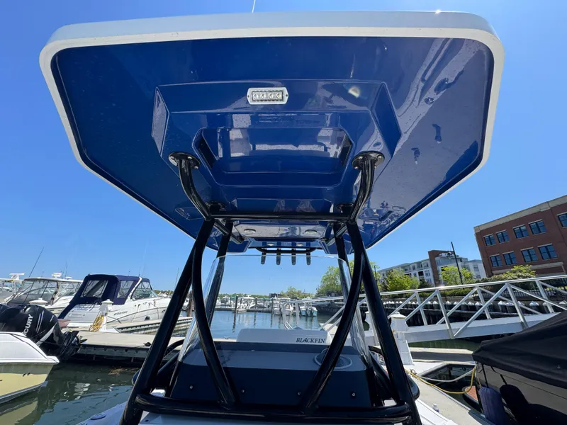 Slide: The Image of 2020 Blackfin 212 CC boat with blue T-top at marina. - 29