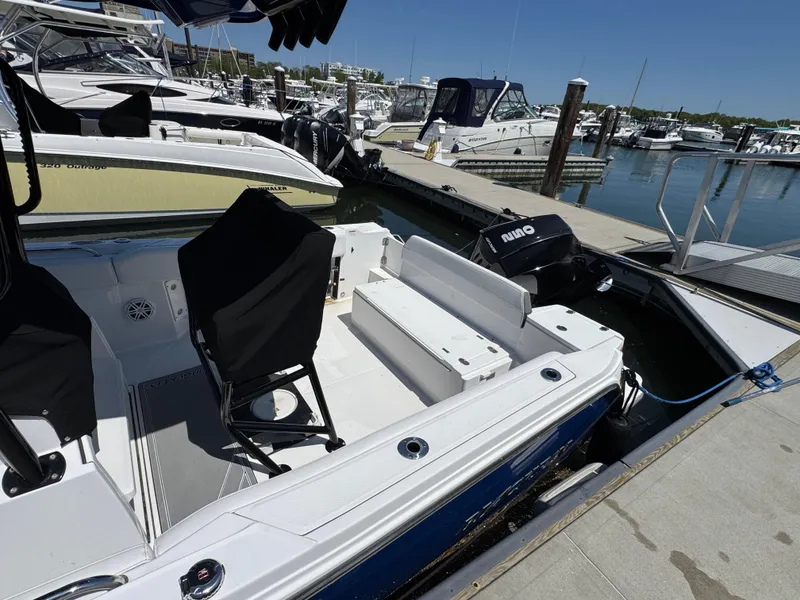 Slide: The Image of 2020 Blackfin 212 CC boat docked at marina with seating and outboard motor. - 3