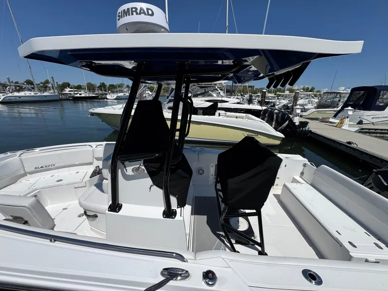 Slide: The Image of 2020 Blackfin 212 CC boat with T-top, docked at marina, featuring spacious seating. - 4
