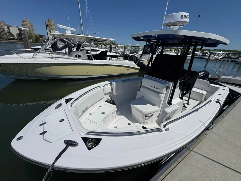 Slide: The Image of 2020 Blackfin 212 CC boat docked at marina, featuring sleek design and modern equipment. - 5