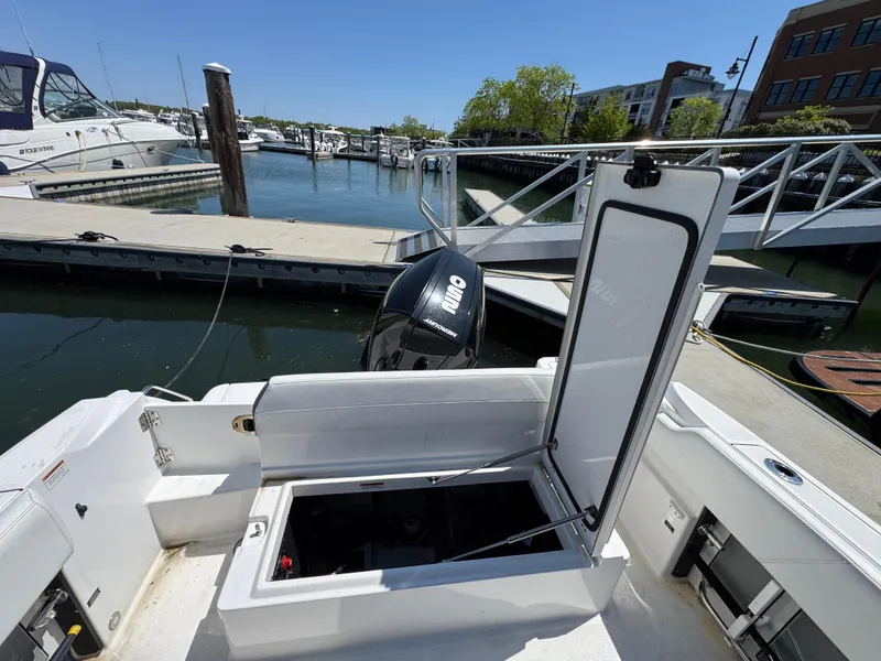 Slide: The Image of 2020 Blackfin 212 CC boat docked, open storage compartment, marina background. - 8