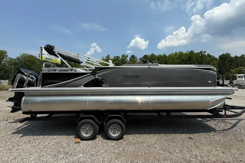 The Image of 2025 Tahoe Pontoon LTZ Cruise on trailer, parked outdoors under a partly cloudy sky. - 0