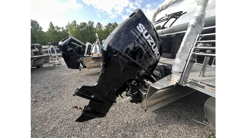 Slide: The Image of 2025 Tahoe Pontoon LTZ Cruise with Suzuki outboard motor in a gravel lot. - 14