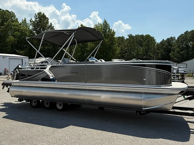 Slide: The Image of 2025 Tahoe Pontoon LTZ Cruise boat with canopy, parked outdoors on a sunny day. - 2