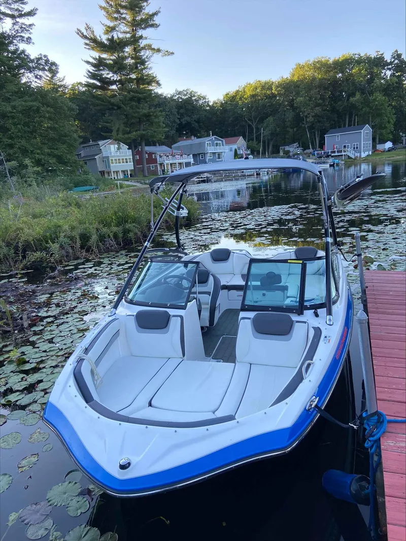 Slide: The Image of 2015 Yamaha Boats AR192 docked on a serene lake with surrounding greenery. - 1
