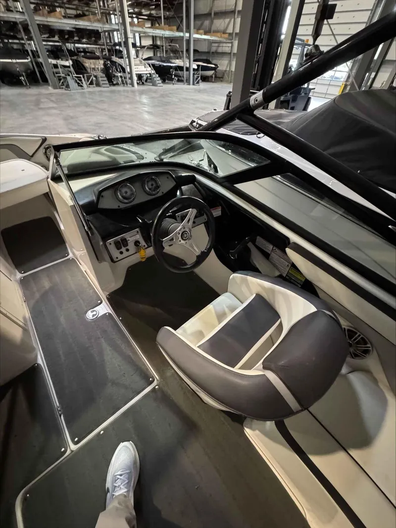 Slide: The Image of 2015 Yamaha Boats AR192 interior with steering wheel and dashboard in a warehouse setting. - 7