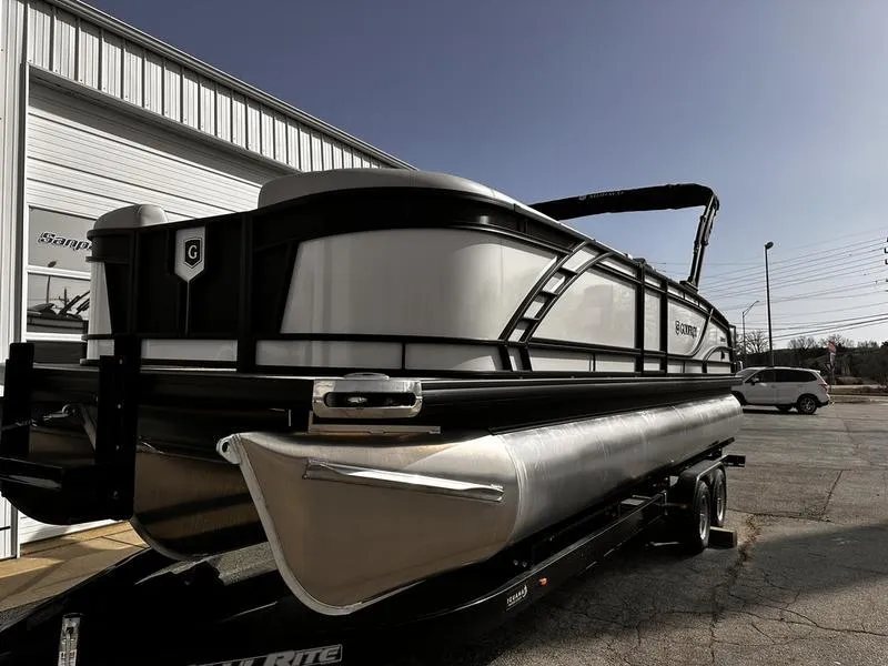 Slide: The Image of 2025 Godfrey Monaco 255 DFL iMPACT pontoon boat on trailer, parked outdoors. - 15