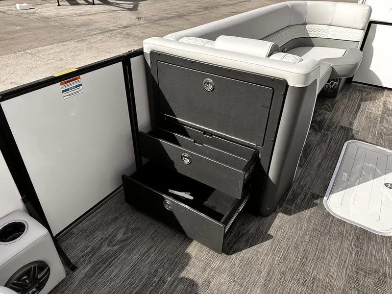 Slide: The Image of 2025 Godfrey Monaco 255 DFL boat interior with open storage drawers and seating. - 5