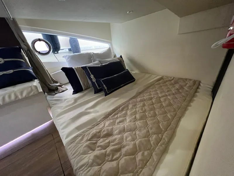 Slide: The Image of Luxurious cabin interior of 2022 Evolve 400HT yacht with elegant bedding and porthole window. - 12