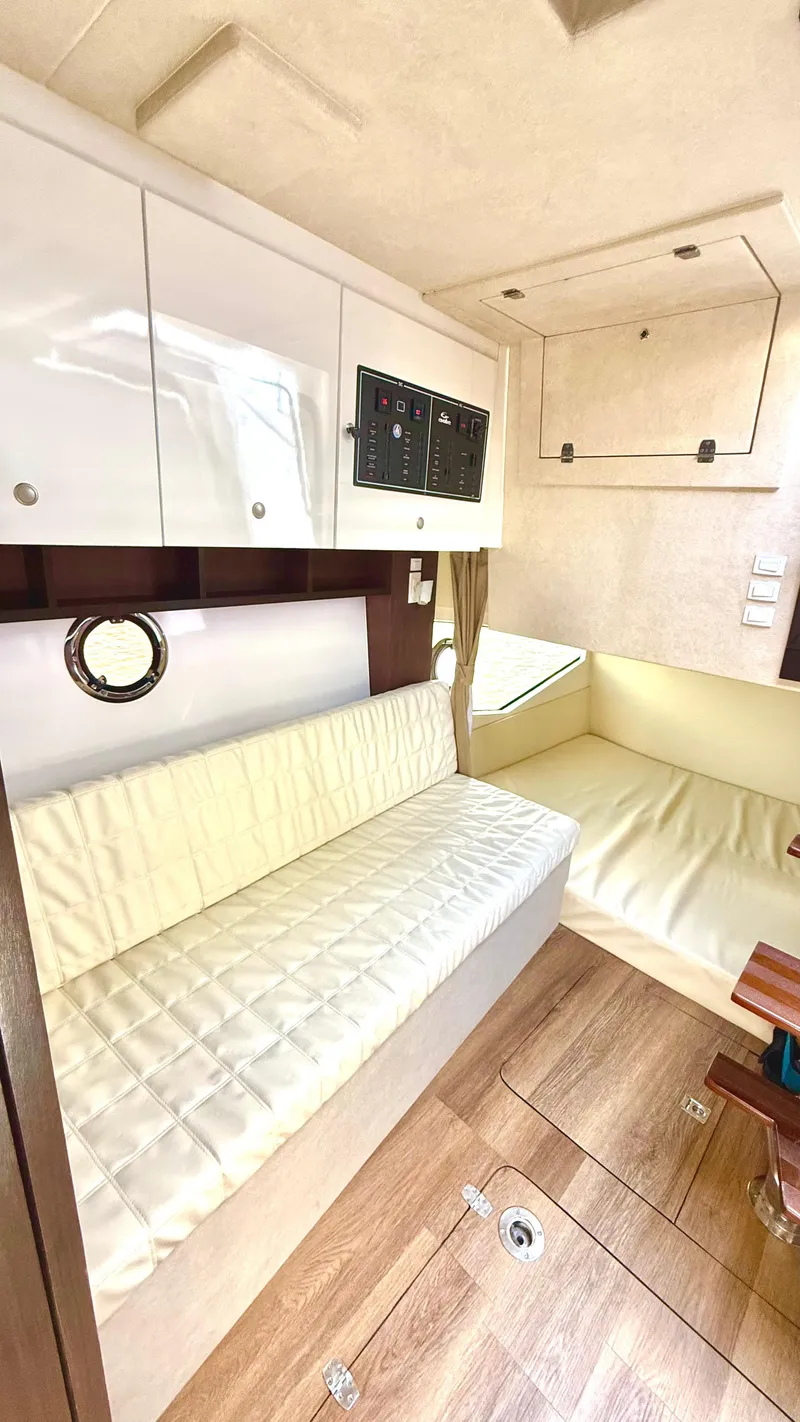 Slide: The Image of Interior of 2022 Evolve 400HT boat with white seating and wood flooring. - 16