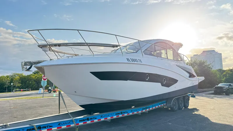 Slide: The Image of Evolve 400HT 2022 yacht on trailer, sunlit background, parked in urban setting. - 27