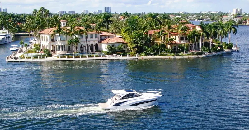 Slide: The Image of Evolve 400HT yacht cruising near luxurious waterfront estate, 2022 model. - 5