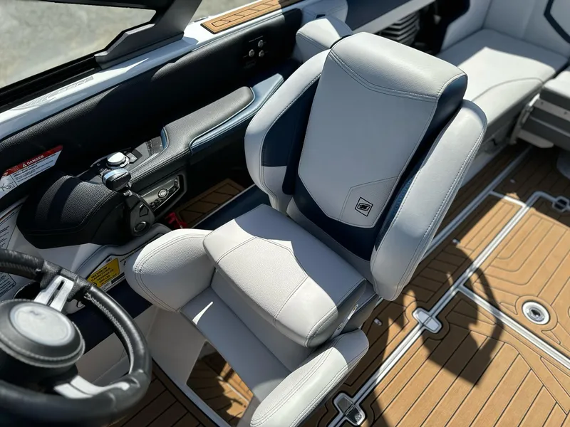 Slide: The Image of 2019 Nautique Super Air G23 boat interior with sleek captain's chair and modern dashboard. - 10