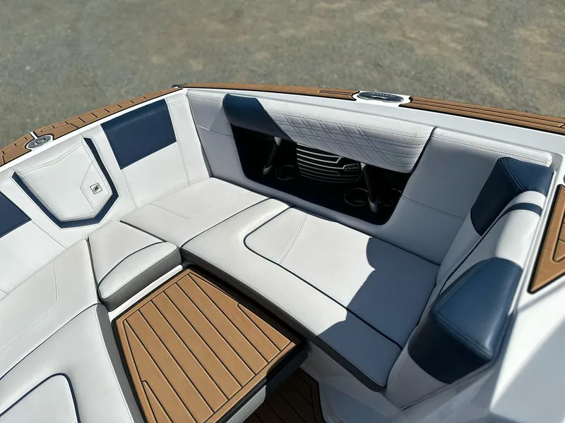Slide: The Image of 2019 Nautique Super Air G23 boat interior with white and blue seating, wooden accents. - 21