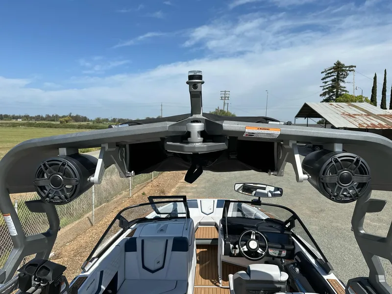 Slide: The Image of 2019 Nautique Super Air G23 boat interior with speakers and steering wheel, under a clear sky. - 25