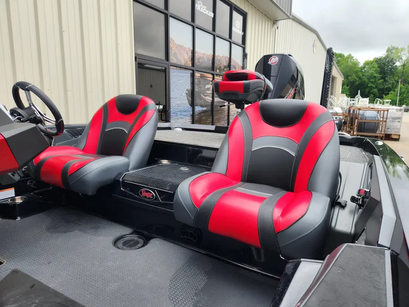 Slide: The Image of 2022 Ranger Z521L boat interior with red and black seats, parked near a building. - 10