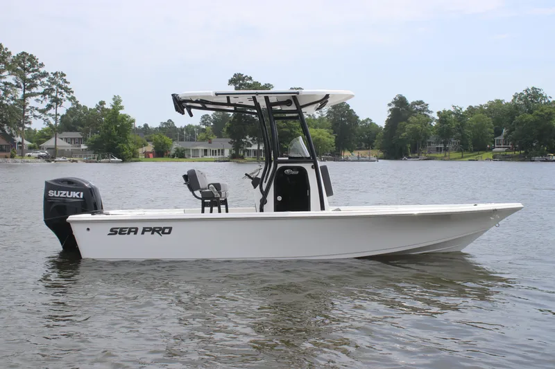 Slide: The Image of 2025 Sea Pro 210 boat on a calm lake with trees in the background. - 0