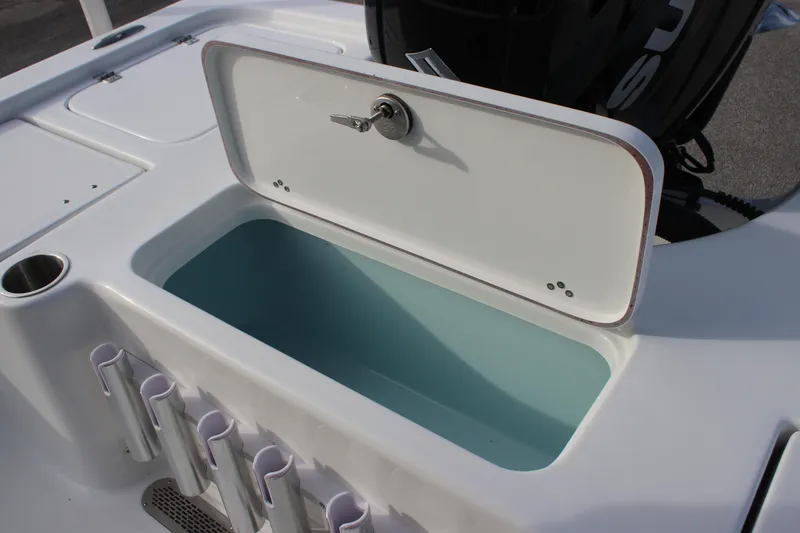 Slide: The Image of 2025 Sea Pro 210 boat livewell with open lid and rod holders. - 23