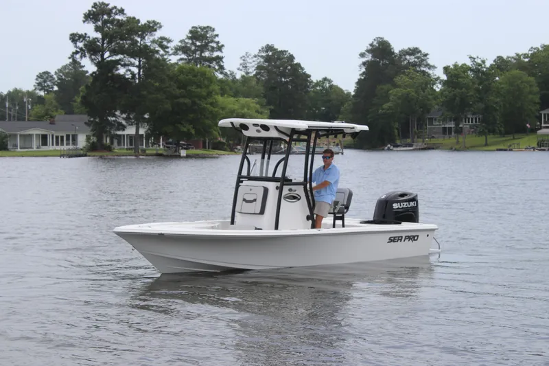 Slide: The Image of 2025 Sea Pro 210 boat on a calm lake with trees in the background. - 29