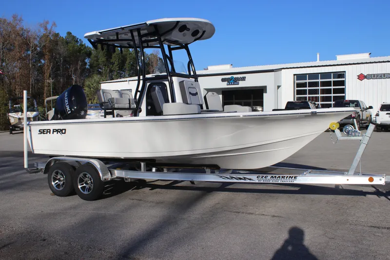 Slide: The Image of 2025 Sea Pro 210 boat on trailer, parked outside dealership under clear blue sky. - 8