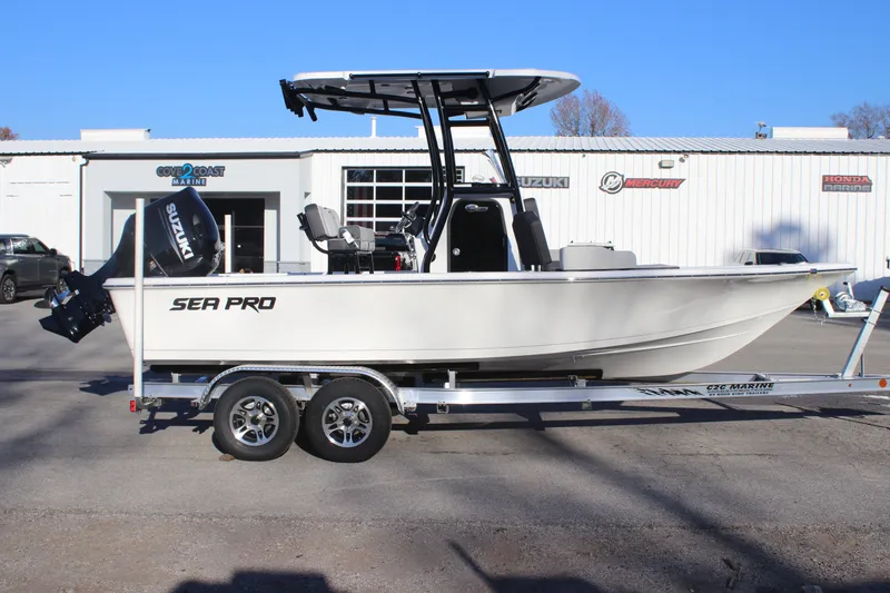 Slide: The Image of 2025 Sea Pro 210 boat on trailer, parked outside dealership, clear blue sky. - 9